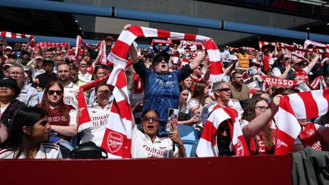 Arsenal fans hold scarves aloft
