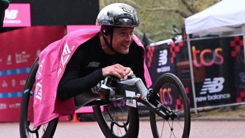 Marcel Hug celebrates winning the men's wheelchair race