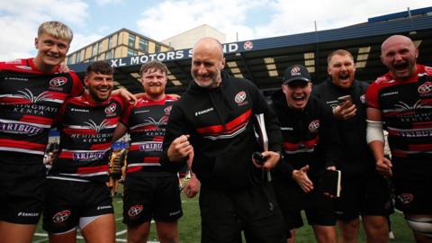 Gavin Cattle surrounded by Cornish Pirates players.