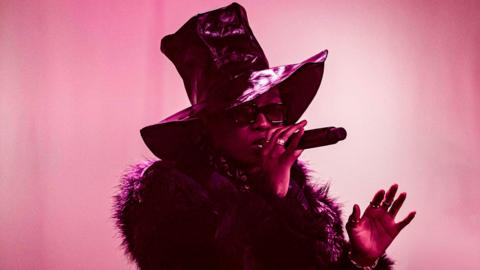 Little Simz performing with a pink hue around her.