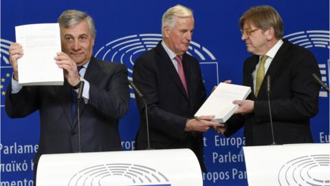 European Parliament President Antonio Tajani holds up a copy of the Brexit withdrawal agreement