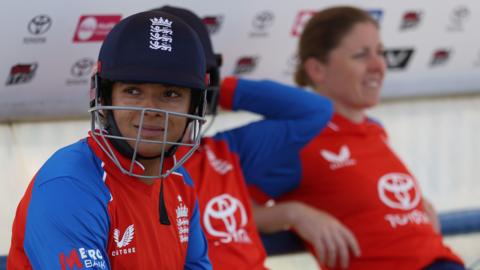 Sophia Dunkley looks on, with her helmet on, while waiting to bat