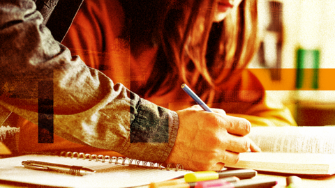 Stock photo of tutor's hand marking work with young girl in background