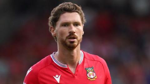 Wrexham midfielder George Evans looks on during a game