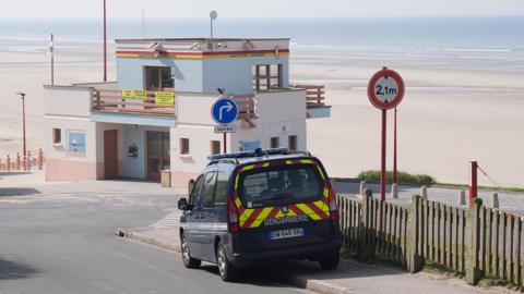 An emergency vehicle which says Gendarmerie on the back, parked up at the beach 