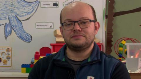 Phil Massey. He is bald, wearing glasses and a blue half-zip fleece.
