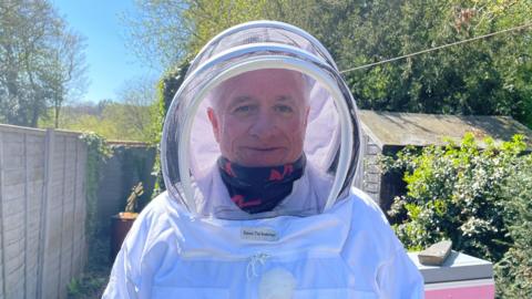 A man in beekeeping gear