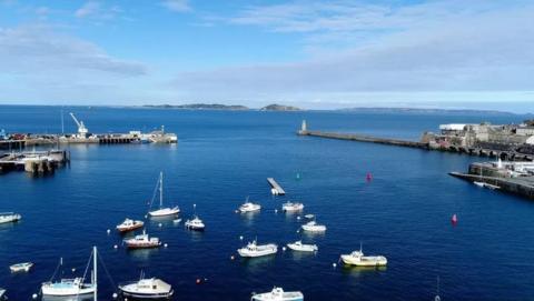 St Peter Port marina, looking out to sea, with several small boats in the foreground