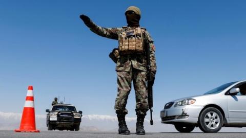 An Afghan National Army soldier stands guard at a checkpoint near Kabul in April 2021