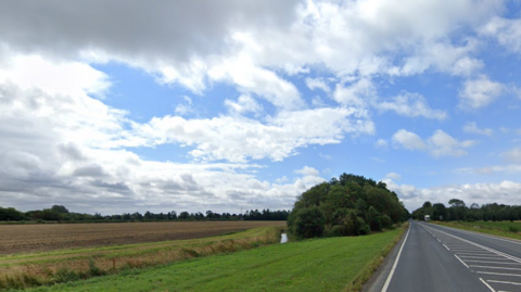 Flat agricultural fields seen from an A-road