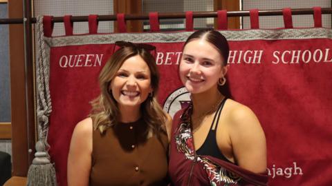 Quayle, and her dance teacher Lewis stand side by side smiling