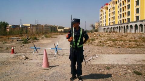 A police officer stands guard near a 'vocational education centre' in Xinjiang
