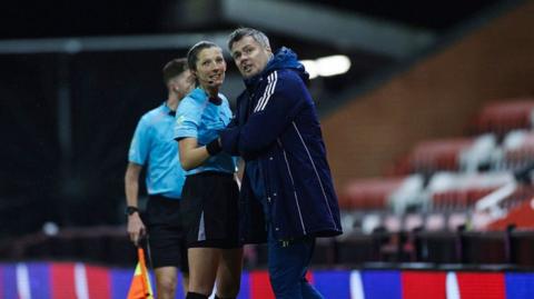 Referee Melissa Burgin explains to Newcastle coach Robbie Stockdale why she has stopped the Premier League 2 clash with Manchester United at Leigh Sports Village