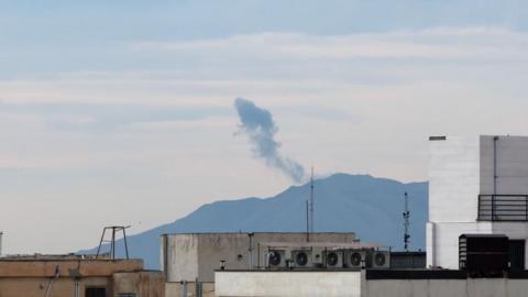 Smoke rises after an air strike in eastern Tehran, Iran