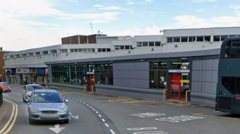 Cars drive along High Street in the town centre near the central bus station.