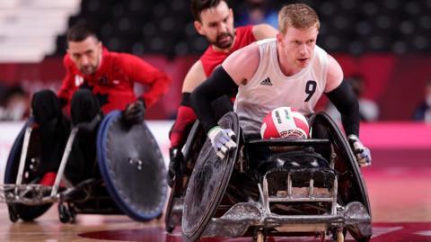 Jim Roberts in a wheelchair with a ball in his lap