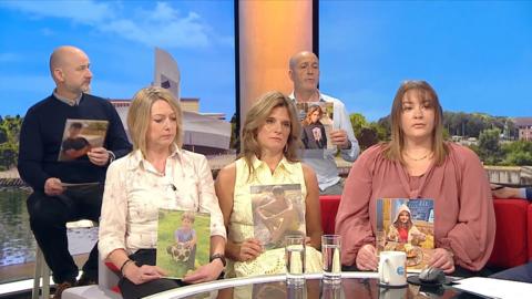 Parents sit with photographs of their children.
