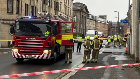 SFRS appliance, firefighters and police at the scene in Paisley with barricade tape around property