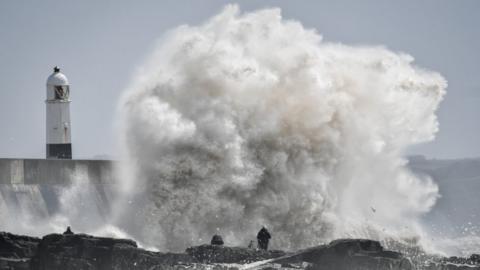 Waves crashing against seawall because of Storm Hannah