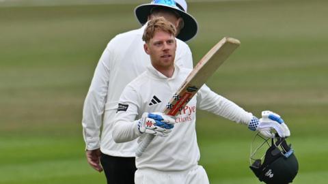 Kyle Verreynne raises his bat towards the Notts dressing room after scoring a century