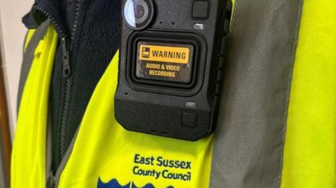 A person in an East Sussex County Council jacket with a bodycam on