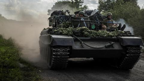 Ukrainian servicemen ride a military vehicle near the Russian border in Sumy region