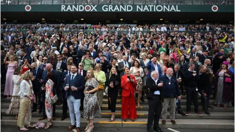 Spectators cheering at Aintree on Grand National day