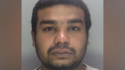 A custody image shows a close-up of Suleman Mukaish facing the camera with a plain light background behind him.