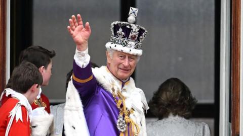 King Charles wearing the Imperial State Crown. He is wearing purple robes. 