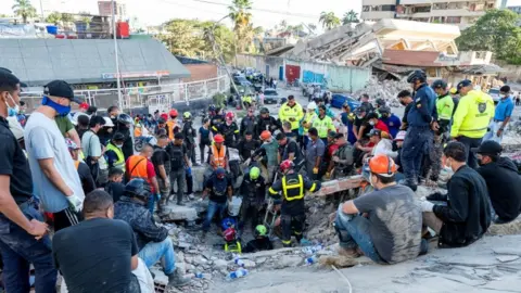 Members of the French Civil Security Training and Intervention Regiment (UIISC 7), US rescuers and other emergency personnel work at collapsed buildings in Caraballeda, La Guaira state