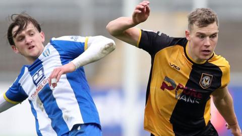 Sven Sprangler (R) of Newport County wins a challenge with Finley Barbrook