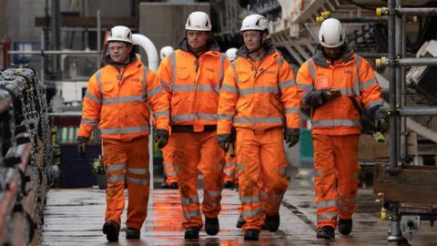 Workmen walk from the tunnel at an HS2 construction site