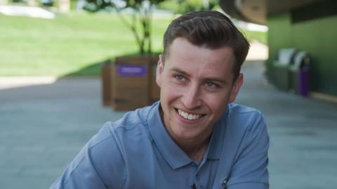 Man in a blue polo shirt smiling