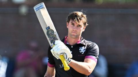 Somerset batter Tom Lammonby raises his bat after scoring a century in the Metro Bank One Day Cup win over Surrey at Taunton