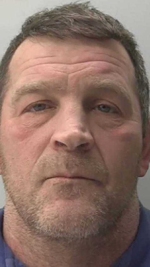 Police mugshot of Paul Quinn he has short brown hair and a short beard