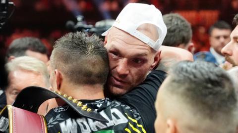 A bruised Tyson Fury is hugged by Oleksandr Usyk in the ring after their fight is over