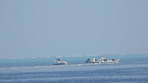 Chinese Coast Guard boats close to the floating barrier are pictured near the Scarborough Shoal