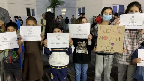 File photo showing Afghan children at a housing facility for asylum seekers in Abu Dhabi protesting against the US failure to resettle them (13 February 2022)