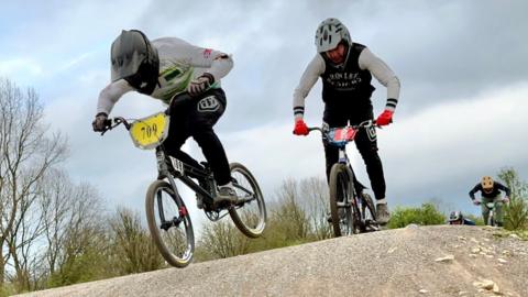 BMX riders going over a bump