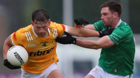 Antrim's Kavan Keenan attempts to fend off London's Ciaran Diver at Corrigan Park 