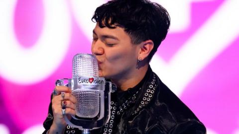 Austrian singer JJ kisses his trophy after winning the 2025 Eurovision Song Contest