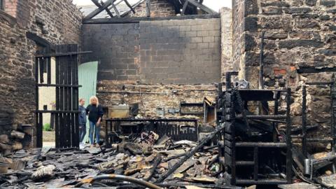 The charred remains of the inside of a stone barn  