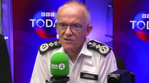 Sir Mark Rowley speaks into a green mic in the BBC Radio 4 studio