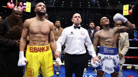 Conor Benn celebrates and Chris Eubank Jr looks up with the referee in the middle following the conclusion of their rematch