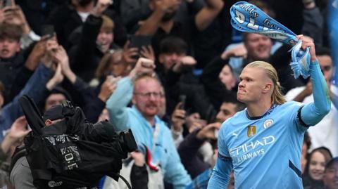 Erling Haaland swirls a scarf around his head in celebration