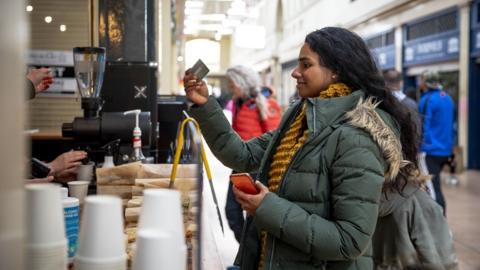 Stock photo of a woman buying a coffee