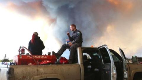 Smoke clouds rise over a rescue vehicle