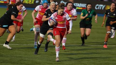 Emily Scott runs with the ball for Harlequins