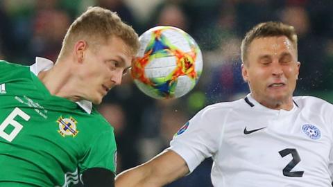 NI midfielder George Saville beats Estonia's Gert Hams to the high ball