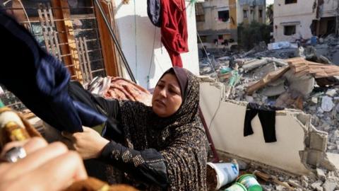 A Palestinian woman hangs laundry at her house that was damaged during Israel-Gaza fighting, as ceasefire holds, in Gaza City August 8, 2022.